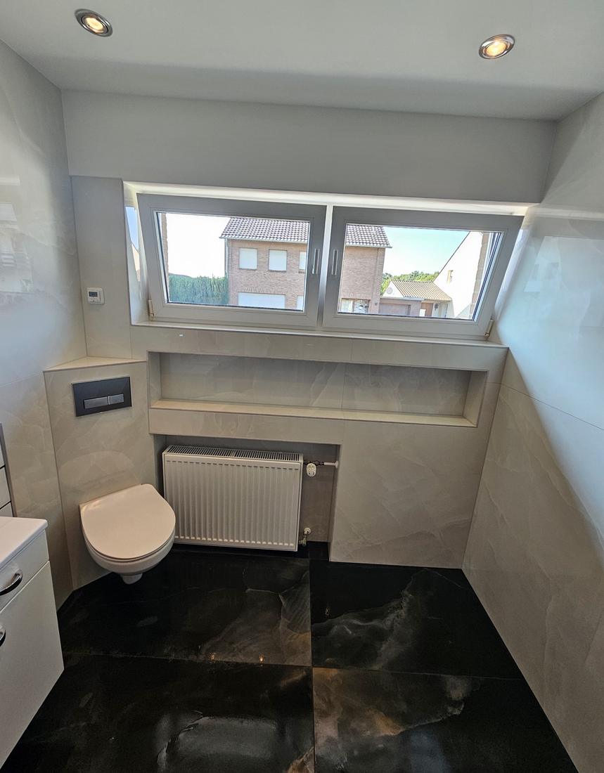 Wand-WC mit Vorwand, gefliester Ablage und Heizkörpernische, Boden in schwarzer Marmoroptik