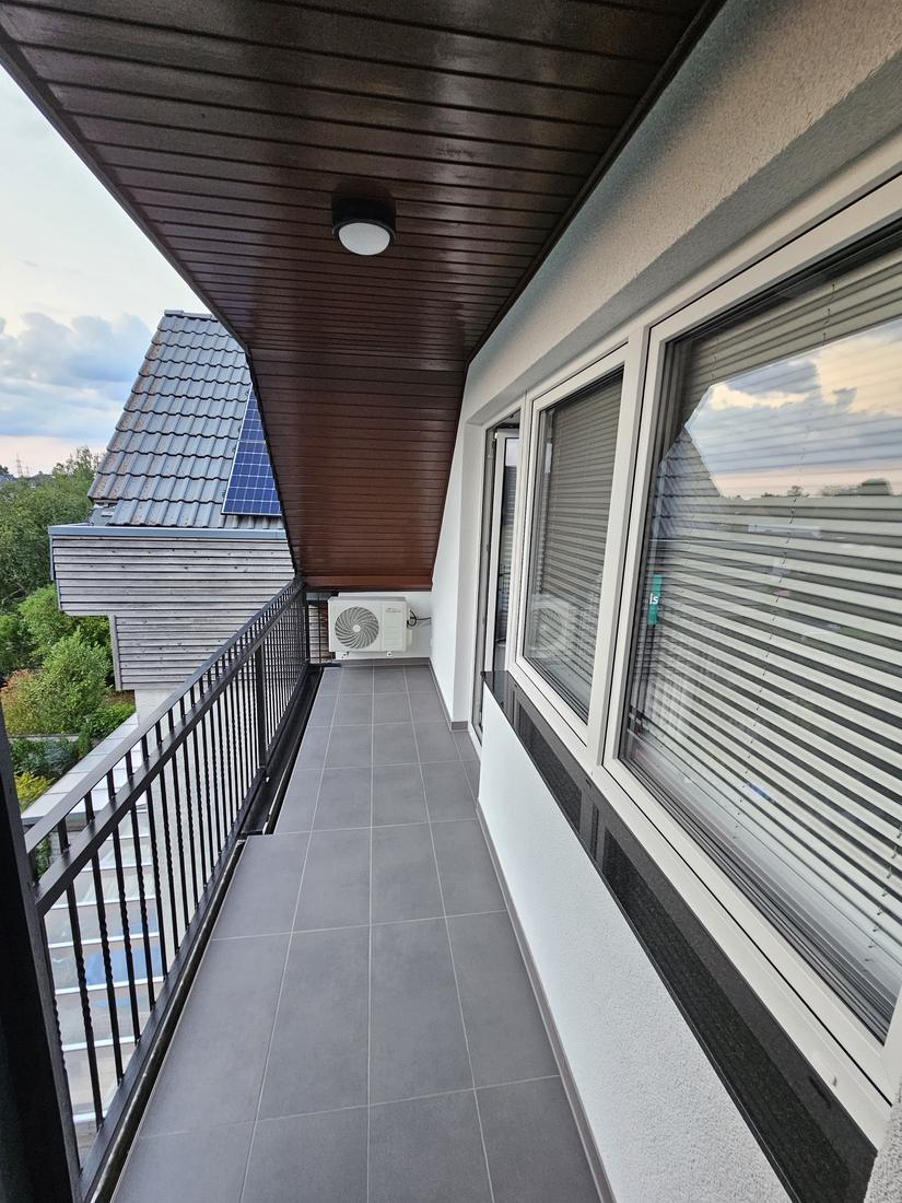 Balkon mit grauen Großformatfliesen und Sockelleisten