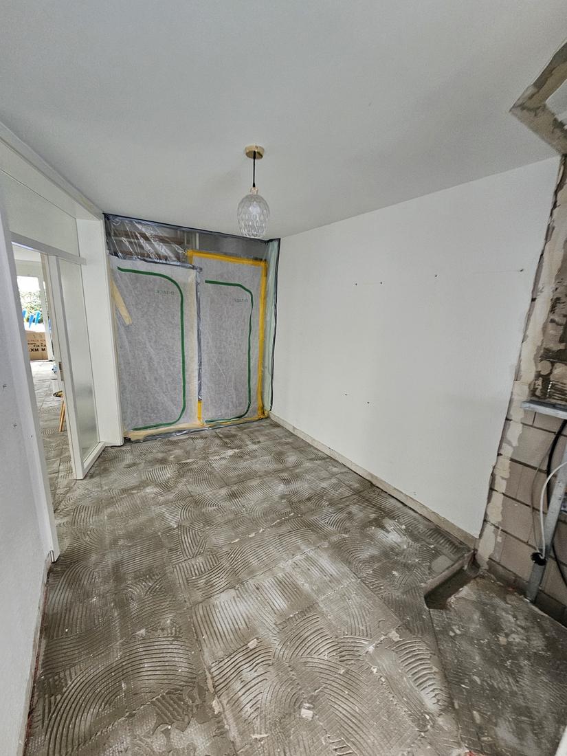 Flur während der Bauphase mit Staubschutzwand und Kleberbett auf dem Boden