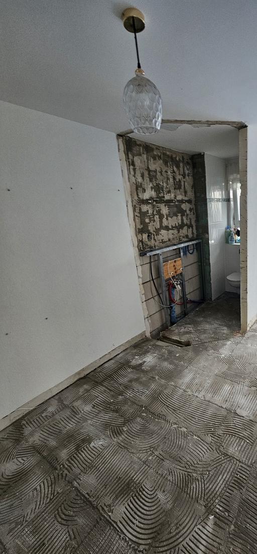 Gäste-WC im Rückbau mit freigelegter Wand und Vorwandinstallation