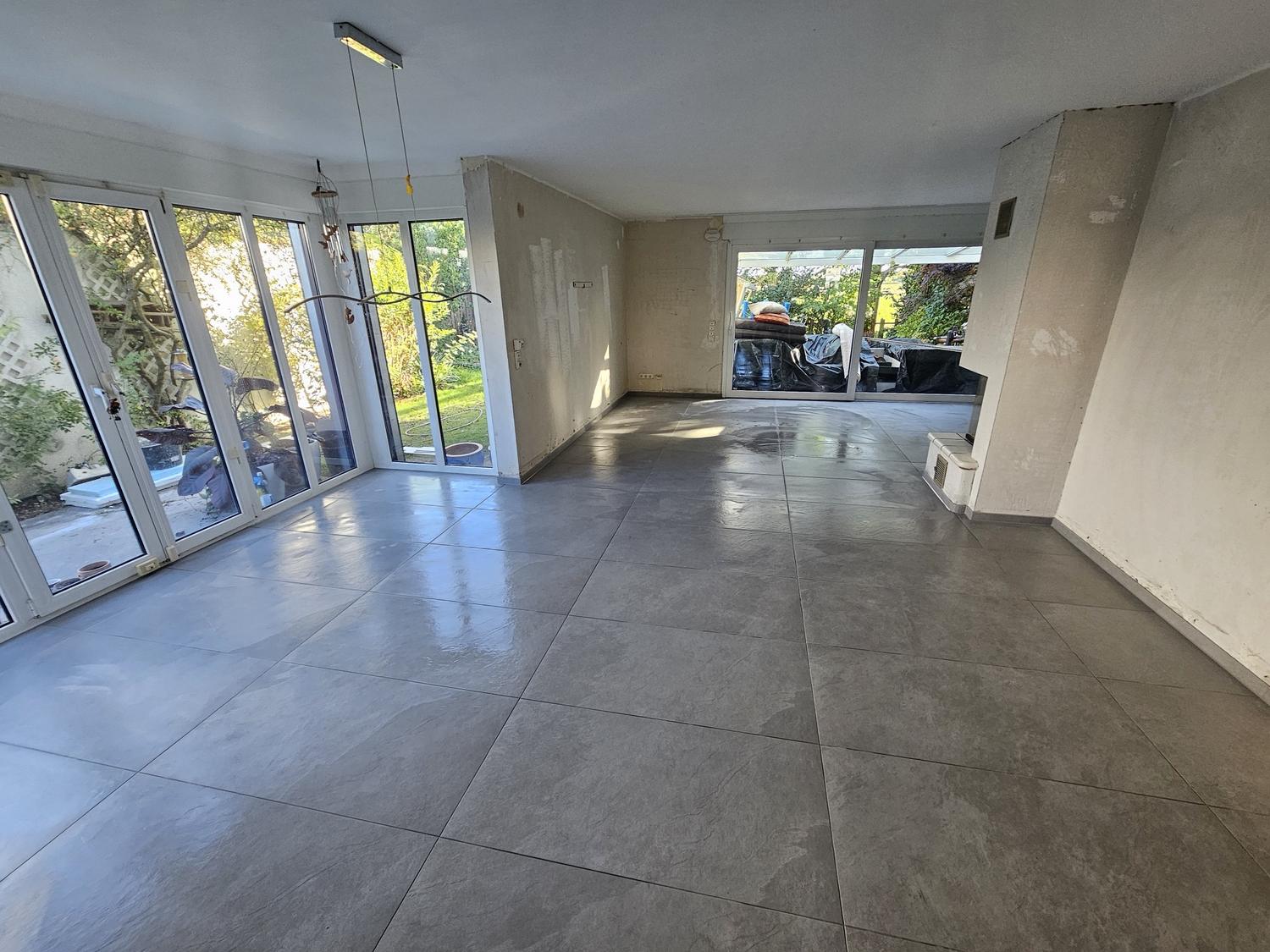 Wohnbereich mit fertig verlegten großformatigen grauen Bodenfliesen